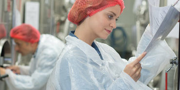 happy scientists posing checking paperwork in factory happy scientists posing checking paperwork in factory