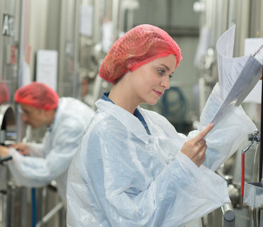 happy scientists posing checking paperwork in factory happy scientists posing checking paperwork in factory