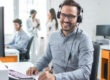 Happy young male customer support executive working in office.
