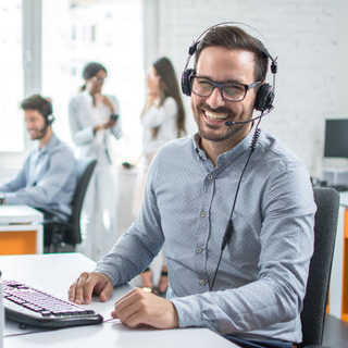 Happy young male customer support executive working in office.