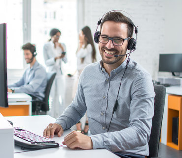 Happy young male customer support executive working in office. Happy young male customer support executive working in office.