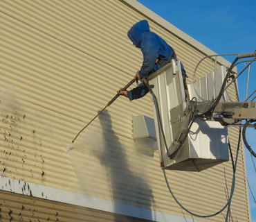 Cleaning a wall with a water jet pressure water blasting commercial cleaning services